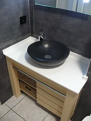 meuble salle de bains en frêne huilé, paniers sisal et plateau en résine type corian. 
